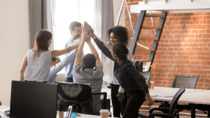 5 colaboradores motivados juntando as mãos no escritório